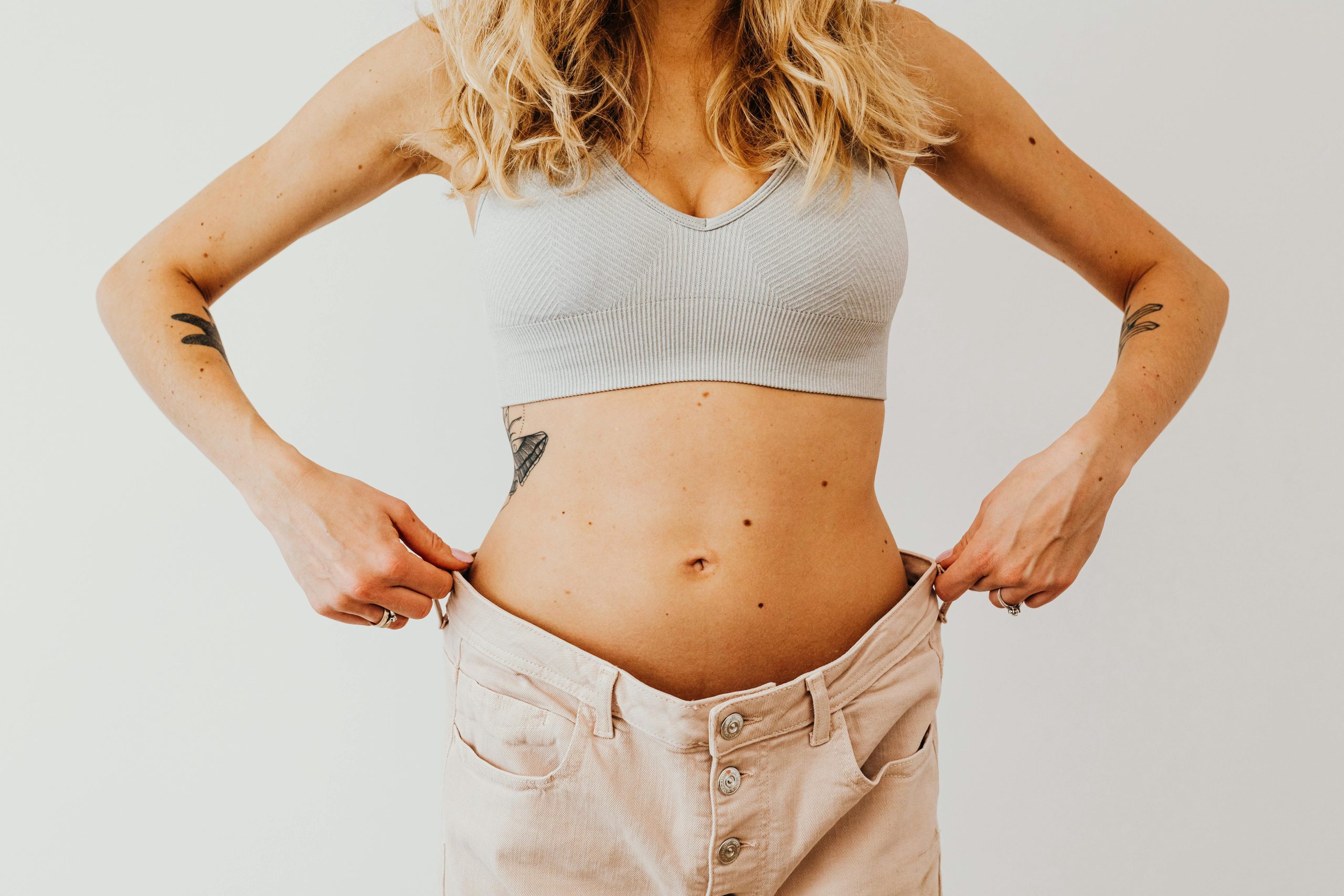 Woman pulling up pants that are too big from weight loss
